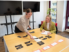 Zwei Mitarbeiter machen ein Card-Sorting auf dem Konferenztisch.