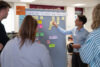 Vier Mitarbeitende stehen vor einer Pinnwand und erarbeiten eine User Journey mithilfe von Post-its.