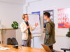 2 junge Männer unterhalten sich vor einem Flipchart