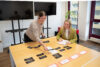 Zwei Mitarbeiter machen ein Card-Sorting auf dem Konferenztisch.